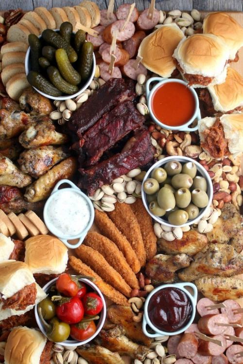 bbq charcuterie board with ribs, wings, olives, sauces