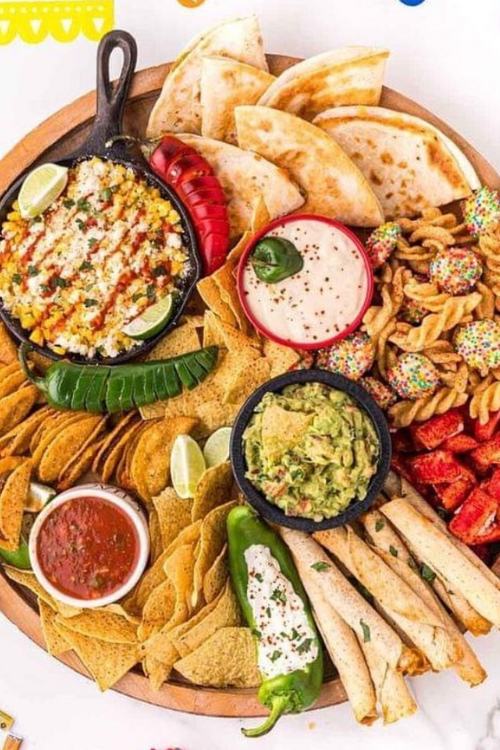 mexican charcuterie board with chips, salsa, guacamole, and elote.