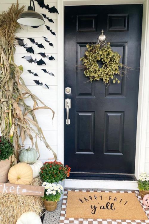 fall front porch with bat decor hanging next to black front door