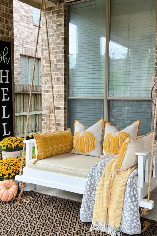 porch swing with yellow pumpkin pillows