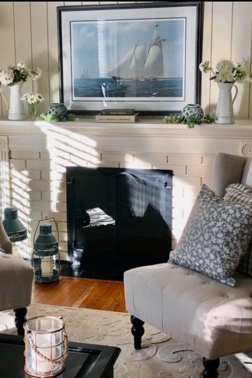 white brick fireplace with framed sailboat art on the mantle