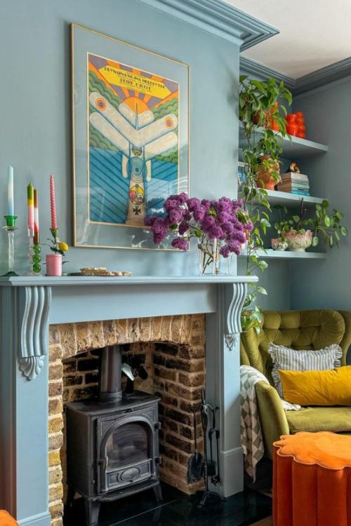 blue fireplace with colorful flowers on mantel