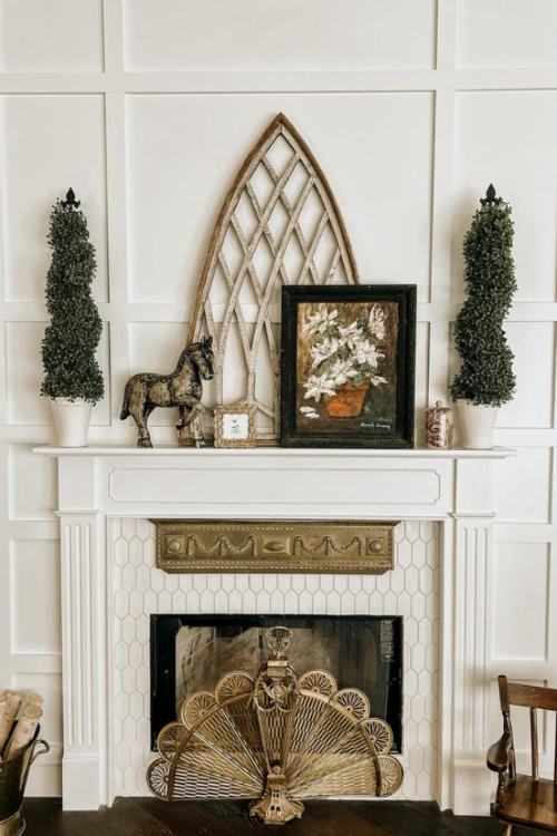 white fireplace with two false shrubs on the mantle