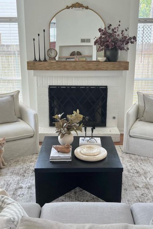 fireplace mantel decor with purple flowers, candle sticks and mirror