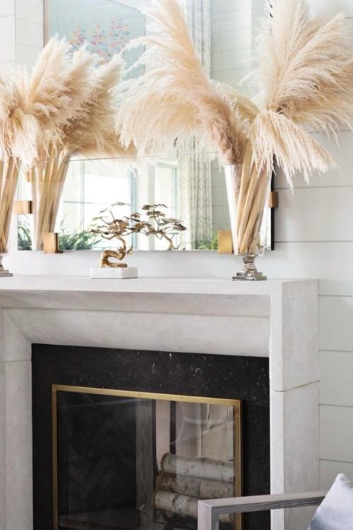 white fireplace with pampas grass in vases as mantel decor