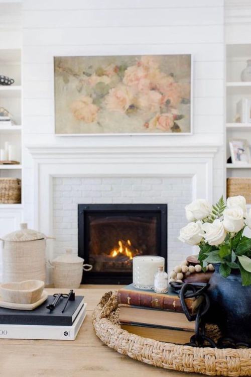 white brick fireplace with large floral painting hanging over mantel