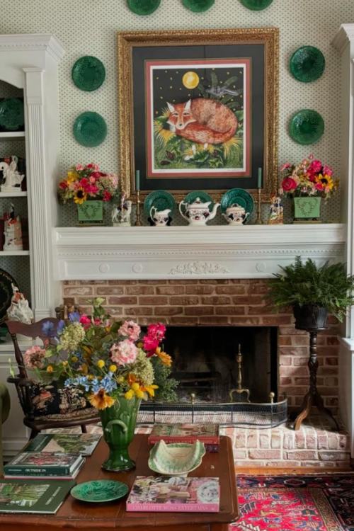 brick fireplace with vintage tea set and ceramic plates over mantel 