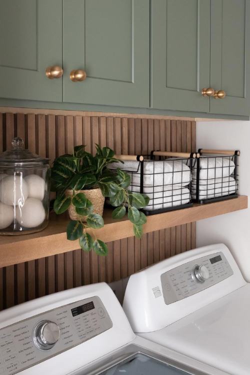 laundry room with sage green cabinets