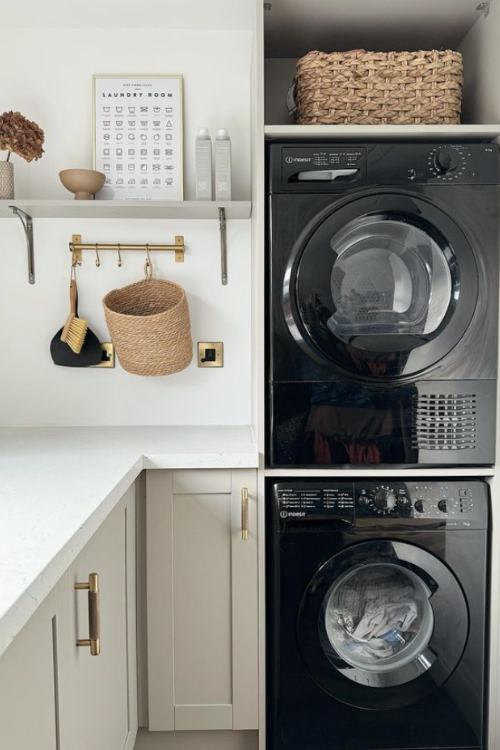 laundry room with stacked washer and dryer, brass hooks with basket hanging