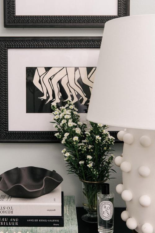 black nightstand with stack of coffee table books and black and white decor