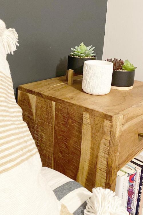 small nightstand with candle and two succulents