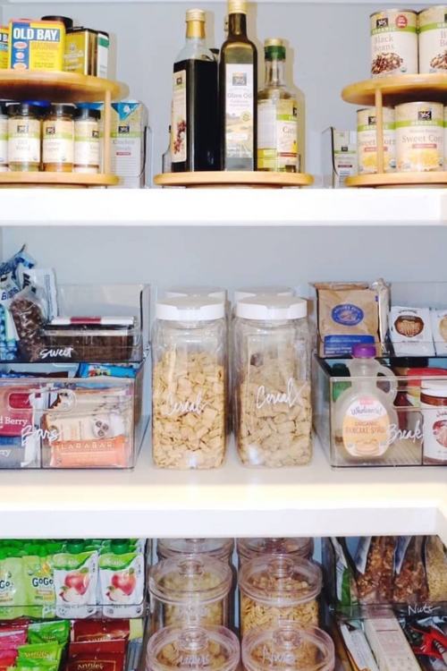 organized pantry with tiered trays, acrylic containers, and lazy susans