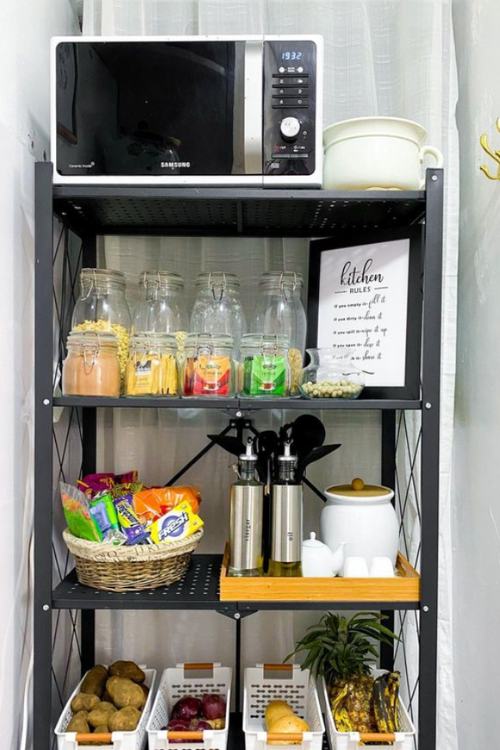 narrow shelf with microwave and containers holding fruit and snacks